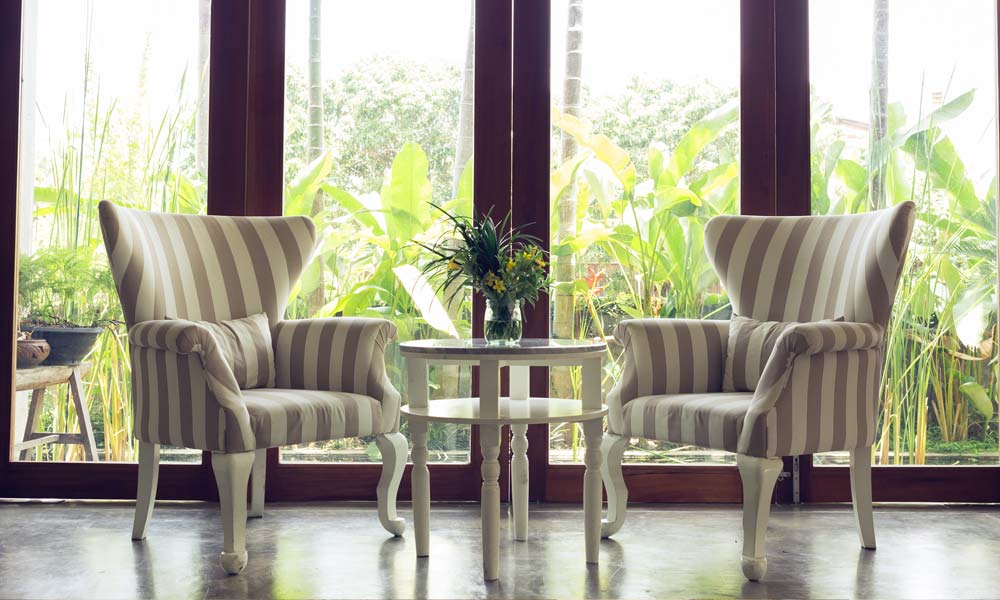 2. Wohnidee für Landhausmöbel: Lebendige Landhausmöbel-Lounge mit Sesseln vor bodentiefen Fenstern