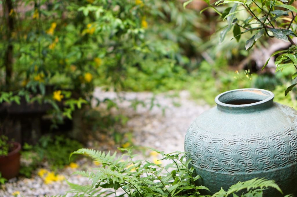 Vasen und Amphoren am Wegesrand geben einem kleinen Garten Tiefe und romantische Verträumtheit