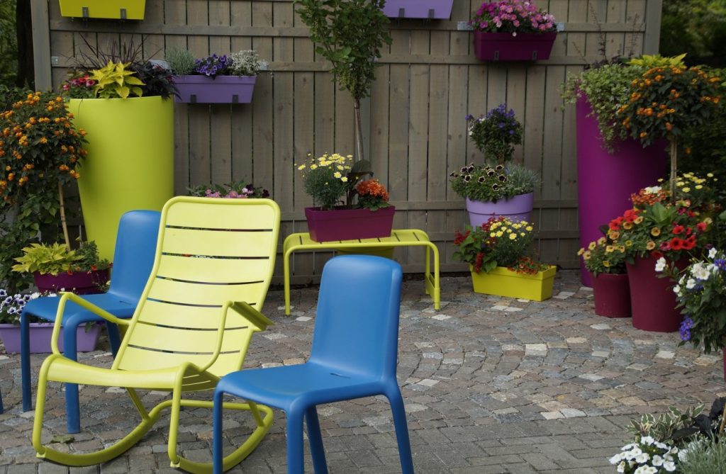 8. Idee: Terrasse mit bunten Planzkübeln und Blumen auf Kopfsteinpflaster