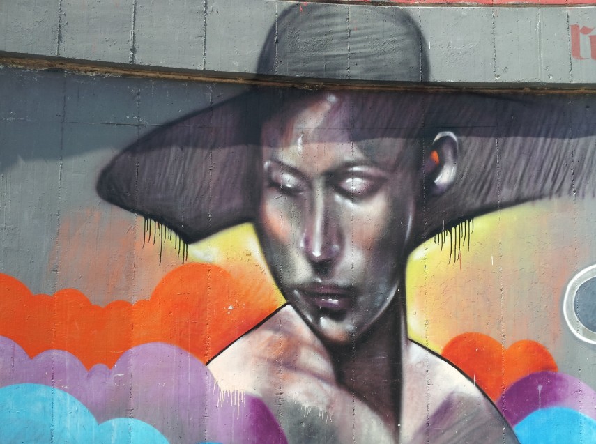 Dieses Graffiti zeigt eine Frau mit mondänem Hut - oder ist es ein Schatten? Nachdenklich und in den Wolken steht sie da. Graffiti kann auch Ruhe und Besinnlichkeit ausstrahlen.
